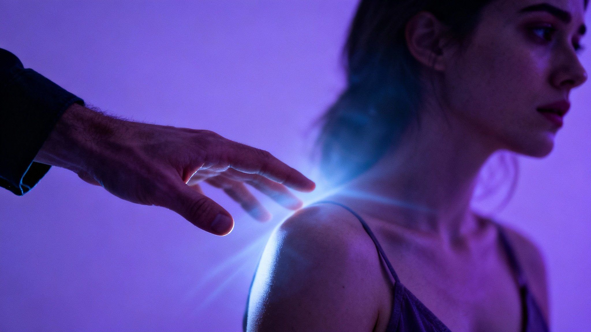 A man's hand hesitates to touch a woman's shoulder, symbolizing the invisible barrier created by the four orgasm killers like pressure and resentment.